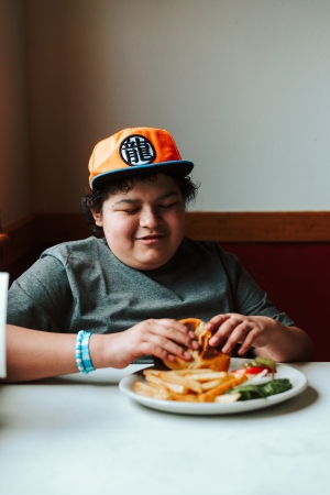 Elijah at enjoy a burger at his familiy's restuarant 